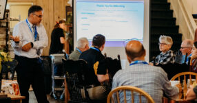 people in seminar with speaker standing and taking questions