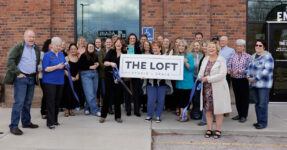 group of people celebrating ribbon cutting of new business