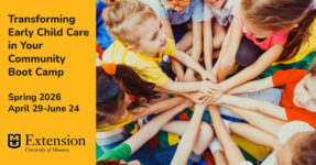 Children sitting in a circle with their hands in center.