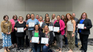 group of adults holding training certs